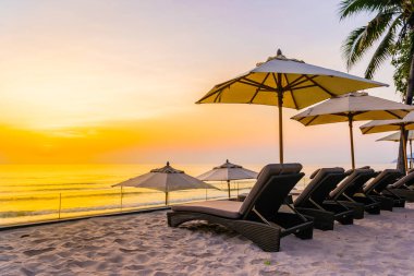 Şemsiye ve güzel plaj ve deniz gündoğumu, sandalyeye tim