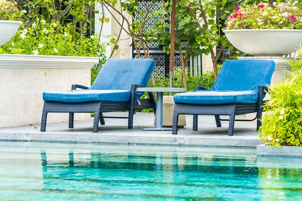 Bela piscina exterior no hotel e resort com cadeira a — Fotografia de Stock