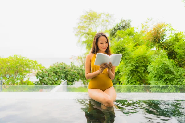 Portrait beautiful young asian woman reading book in swimming po — Stock Photo, Image