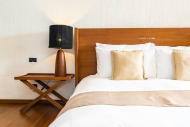 Yatak üzerinde güzel konforlu lüks beyaz yastık ve battaniye Dec