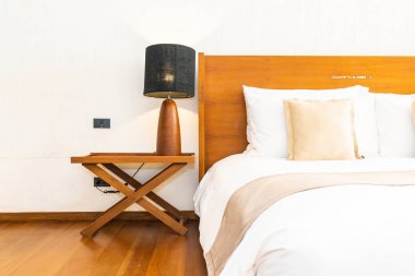 Yatak üzerinde güzel konforlu lüks beyaz yastık ve battaniye Dec