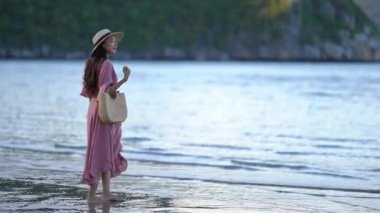 Güzel Asyalı kadının yaz tatilinde deniz kıyısında dinlendiği görüntüler.