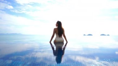 Güzel Asyalı bir kadının oteldeki havuzda dinlenirken çekilmiş görüntüleri.