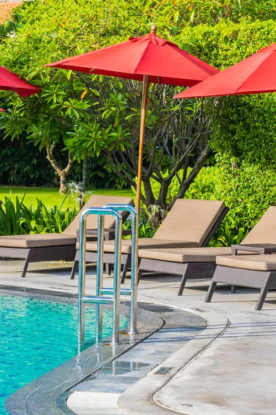 Piękny parasol i krzesło wokół odkrytego basenu w gorącej — Zdjęcie stockowe