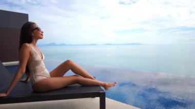Güzel Asyalı bir kadının oteldeki havuzda dinlenirken çekilmiş görüntüleri.