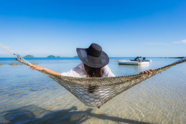 Portre güzel genç Asyalı kadın etrafında hamak üzerinde oturuyor s