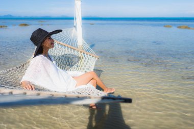 Portre güzel genç Asyalı kadın etrafında hamak üzerinde oturuyor s