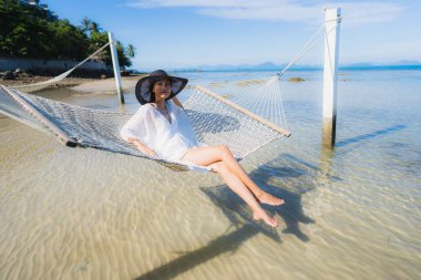 Portre güzel genç Asyalı kadın etrafında hamak üzerinde oturuyor s