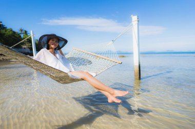 Portre güzel genç Asyalı kadın etrafında hamak üzerinde oturuyor s