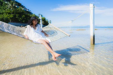 Portre güzel genç Asyalı kadın etrafında hamak üzerinde oturuyor s