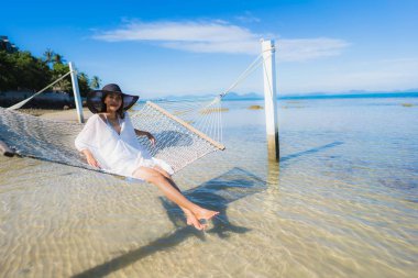 Portre güzel genç Asyalı kadın etrafında hamak üzerinde oturuyor s