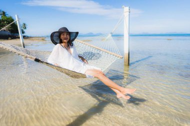 Portre güzel genç Asyalı kadın etrafında hamak üzerinde oturuyor s