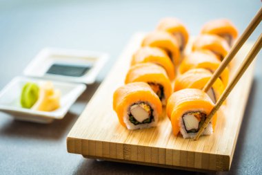 Somon Balık et suşi roll maki ahşap plaka üzerinde