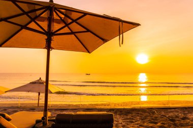 Şemsiye ve güzel plaj ve deniz gündoğumu, sandalyeye tim