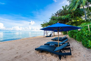 Tropikal plajda güzel şemsiye ve boş yatak sandalyesi ve