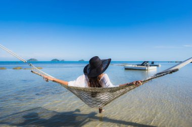 Portre güzel genç Asyalı kadın etrafında hamak üzerinde oturuyor s