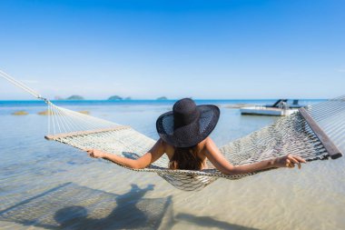 Portre güzel genç Asyalı kadın etrafında hamak üzerinde oturuyor s