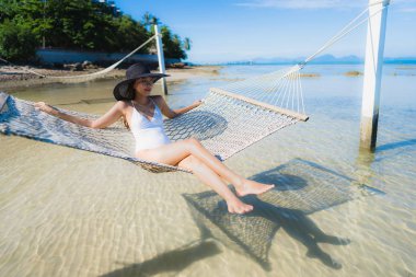 Portre güzel genç Asyalı kadın etrafında hamak üzerinde oturuyor s