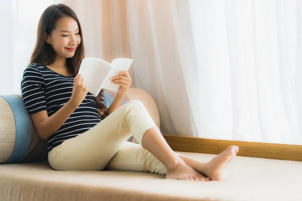 Retrato hermosa joven asiática mujer leyendo libro en en sofá en — Foto de Stock