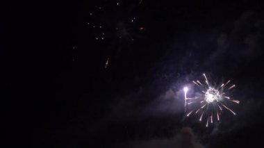 Gece gökyüzünde patlayan havai fişeklerin yakın çekim görüntüleri.