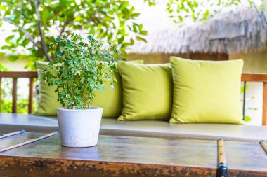 Koltuk koltuğu üzerinde yastık ile masa dekorasyonu vazo bitki