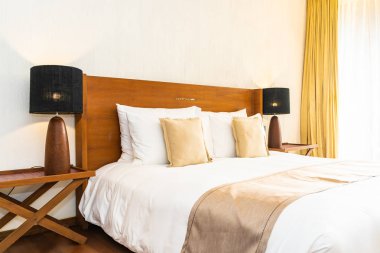 Yatak üzerinde güzel konforlu lüks beyaz yastık ve battaniye Dec