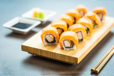 Somon Balık et suşi roll maki ahşap plaka üzerinde