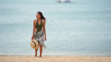 Güzel Asyalı kadının yaz tatilinde deniz kıyısında dinlendiği görüntüler.