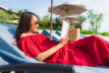 Portre güzel genç Asya kadın okuma kitap içinde yüzme Po