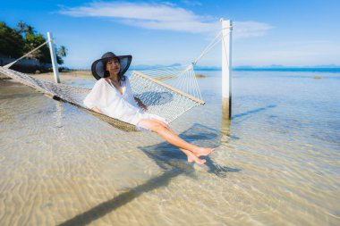 Portre güzel genç Asyalı kadın etrafında hamak üzerinde oturuyor s