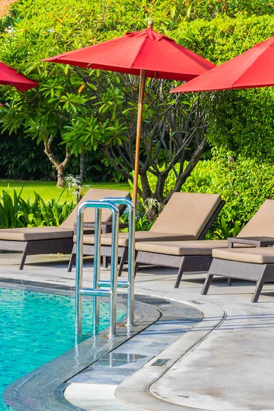 Bellissimo ombrellone e sedia intorno alla piscina all'aperto in caldo — Foto Stock