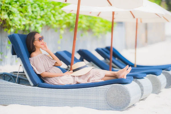 Portret mooie jonge Aziatische vrouw op de stoel met paraplu — Stockfoto