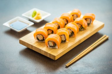 Somon Balık et suşi roll maki ahşap plaka üzerinde