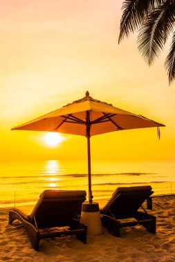 Şemsiye ve güzel plaj ve deniz gündoğumu, sandalyeye tim