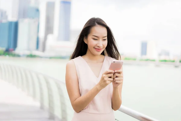 Mujer asiática usando teléfono inteligente o móvil para hablar o texto — Foto de Stock