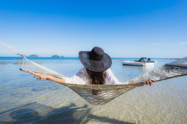 Portre güzel genç Asyalı kadın etrafında hamak üzerinde oturuyor s