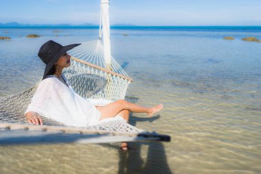 Portre güzel genç Asyalı kadın etrafında hamak üzerinde oturuyor s