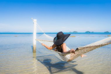 Portre güzel genç Asyalı kadın etrafında hamak üzerinde oturuyor s