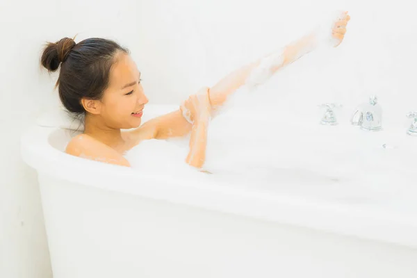 아름 다운 젊은 아시아 여자에 걸릴 초상화를 욕조 욕실에 — 스톡 사진