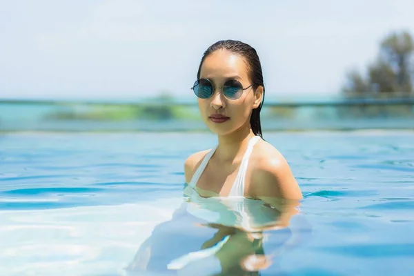 Mooie jonge Aziatische vrouw gelukkig en glimlach in zwembad — Stockfoto