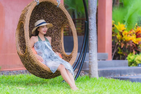 Porträt junge Asiatin sitzt auf Schaukelstuhl im Garten — Stockfoto