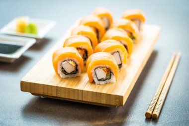Somon Balık et suşi roll maki ahşap plaka üzerinde