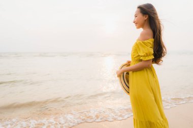 Portre güzel genç Asyalı kadın yürüyüş üzerinde plaj ve deniz o