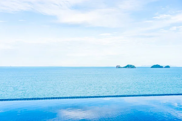 Beautiful outdoor swimming pool with sea ocean on white cloud bl — Stock Photo, Image