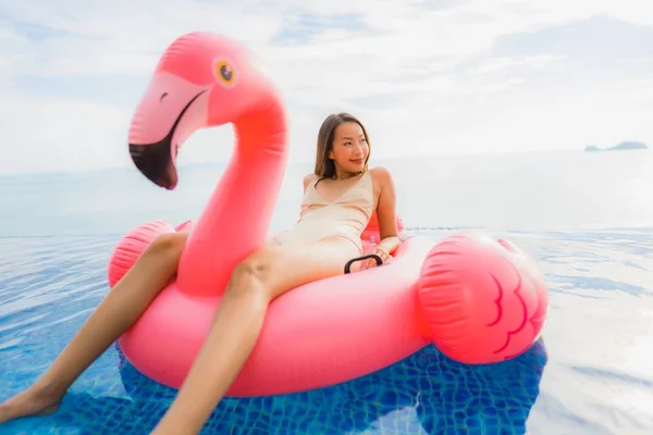 Portré fiatal ázsiai nő a felfújható úszó flamingó körül o — Stock Fotó