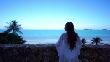 Güzel Asyalı kadının yaz tatilinde deniz kıyısında dinlendiği görüntüler.