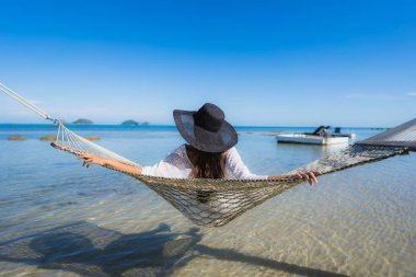 Portre güzel genç Asyalı kadın etrafında hamak üzerinde oturuyor s
