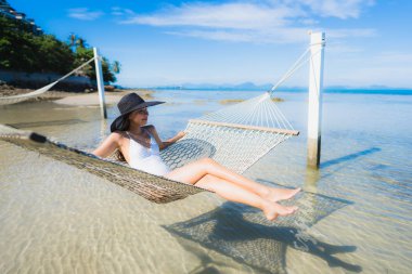 Portre güzel genç Asyalı kadın etrafında hamak üzerinde oturuyor s