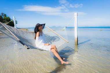 Portre güzel genç Asyalı kadın etrafında hamak üzerinde oturuyor s