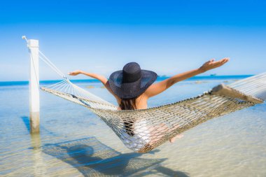 Portre güzel genç Asyalı kadın etrafında hamak üzerinde oturuyor s